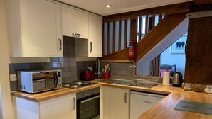 A modern kitchen with white cabinets, a microwave, a stove, and a dishwasher. - The Oaks - Award Winning Barn Conversion In Hope Village Near To Castleton (Hope)