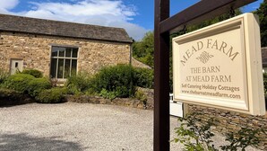 A stone building with a sign for 'MEAD FARM The Barn at Mead Farm Self Catering Holiday Cottages'. - The Oaks - Award Winning Barn Conversion In Hope Village Near To Castleton (Hope)