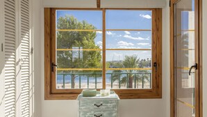 Una habitación con un ventanal que ofrece vistas a una playa y palmeras.