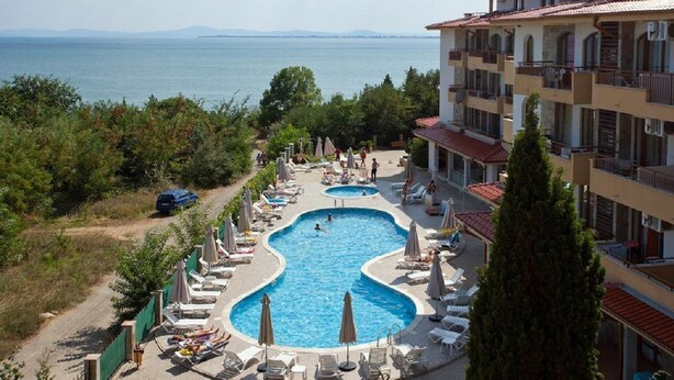 A hotel with a pool area, multiple swimming pools, and a view of the sea. - Dream Holiday Aparthotel (Nessebar)