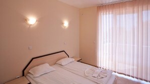A hotel room with a bed, two bedside tables, and two wall-mounted lights. - Dream Holiday Aparthotel (Nessebar)