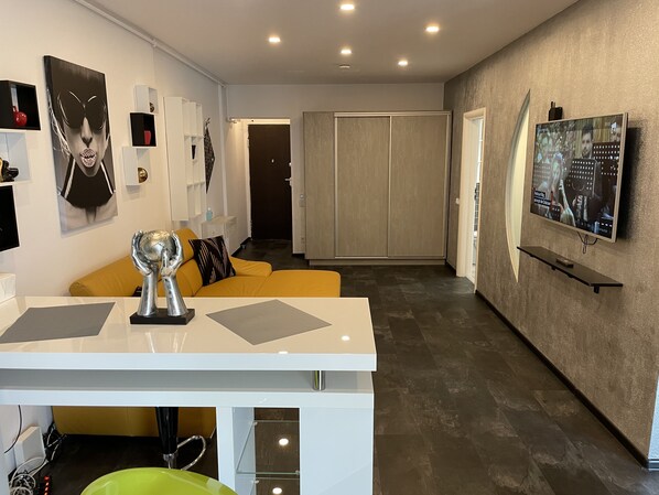 Una sala de estar moderna con un sofá, una mesa de centro y un televisor montado en la pared.