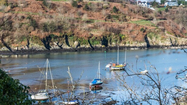 A calm river with boats docked, surrounded by a hilly landscape with houses. - Rock Cottage - 3 Bedroom Holiday Home - Fishguard (Fishguard)