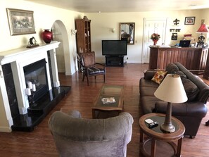 Télévision, cheminée, lecteur de DVD, livres