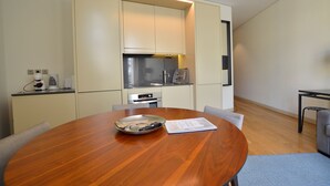 A modern kitchen with built-in appliances, a dining table with chairs, and a notebook on the table. - Dom Luis I Prestige Flat 18 (Lisboa)