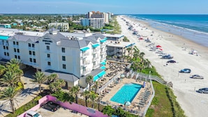 A hotel with multiple floors, a swimming pool, and a beach view. - New Smyrna Beach Townhouse/flagler Ave/beach/walk Everywhere and Pet Friendly! (New Smyrna Beach)
