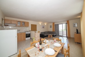 A modern apartment with a kitchen, dining area, and living room.