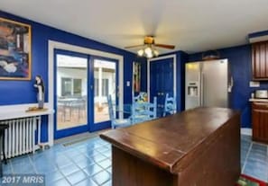 Enjoy cooking in this well-equipped kitchen with a central island, ceiling fan, and refrigerator.