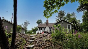 A residential area with two houses, a stone pathway, and a porch. - Cabin by the Creek with private creek access - (Tannersville)