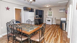 Una cocina compacta con comedor, ventilador de techo y una decoración con forma de estrella en la pared.