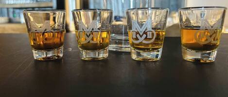 Cuatro vasos exprimidor con un logotipo sobre una superficie oscura.