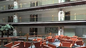 A multi-level atrium with seating areas and a palm tree. - Dazhong Airport Hotel (Shanghai)