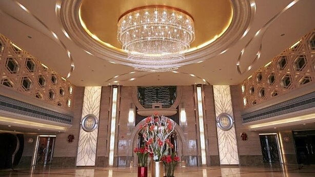 A spacious lobby with a large chandelier, decorative vases, and a polished floor. - Dazhong Airport Hotel (Shanghai)