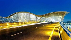 A modern bridge with a glass facade and a curved design. - Dazhong Airport Hotel (Shanghai)