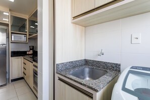 Een koelkast, een oven, een kookplaat, een koffiezetapparaat/waterkoker