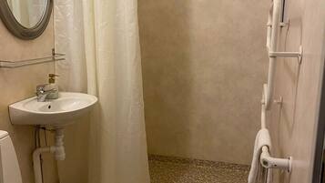 Ein Badezimmer mit Toilette, Waschbecken und Duschbereich.