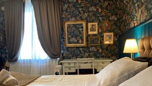 Quarto de hotel com cama, escrivaninha e luminária.
