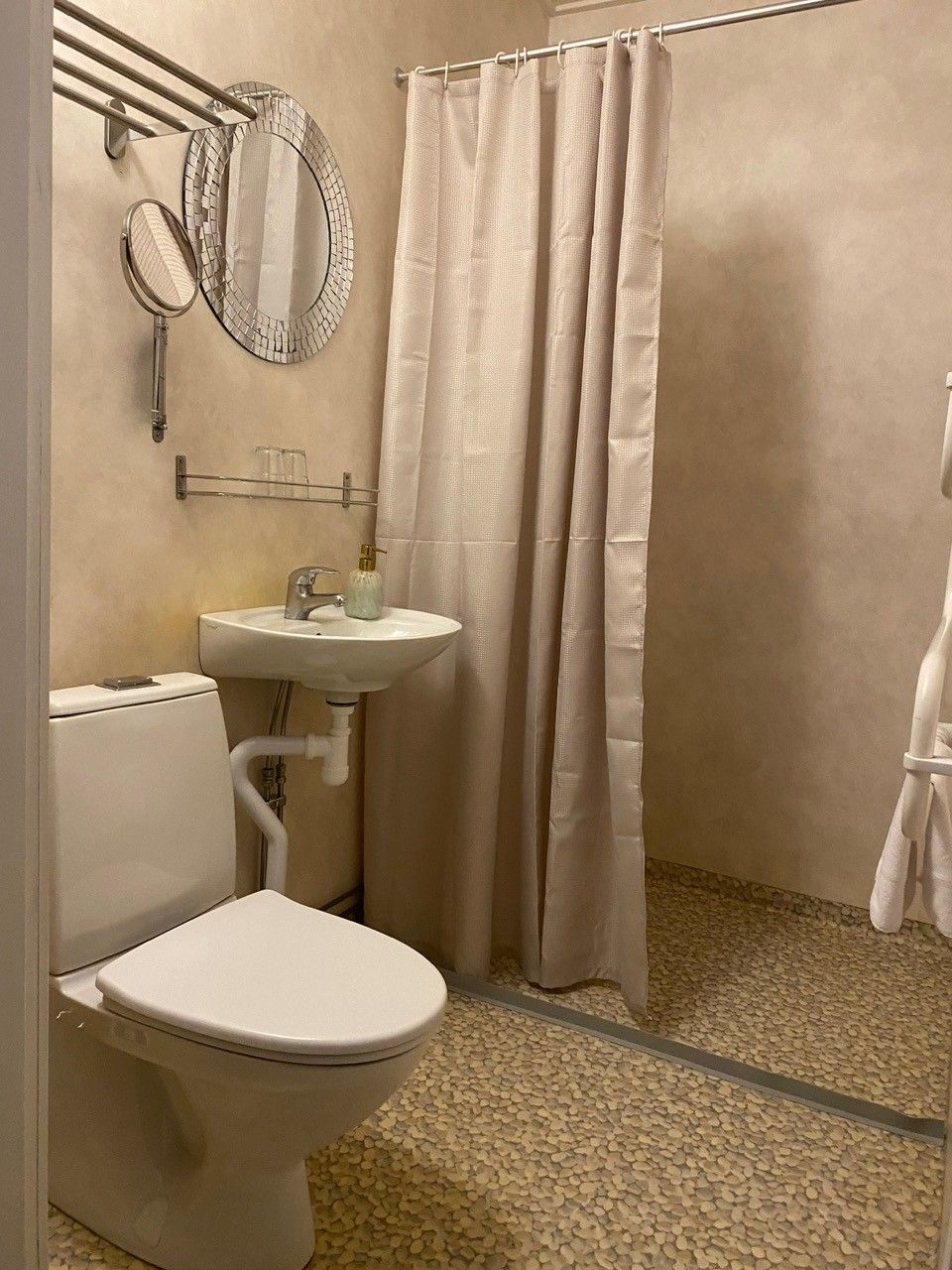 Une salle de bain équipée de toilettes, d’un lavabo et d’un rideau de douche.