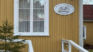 Um edifício amarelo com uma janela branca e uma placa com a inscrição "Hôtel Tussilaingo Essunga".