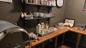 Uma mesa de pequeno-almoço com várias opções de comida, um relógio e uma torradeira.