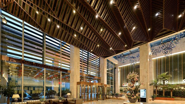 A spacious lobby with a high ceiling, large windows, and a central seating area. - Ramada by Wyndham Xi'an Long march (Xi'an)
