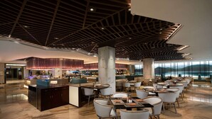 A spacious hotel lobby with a modern design, featuring a central bar area, multiple seating arrangements, and a high ceiling with a geometric pattern. - Ramada by Wyndham Xi'an Long march (Xi'an)