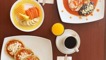 Una mesa de comedor con un plato de comida, una taza de café y cubiertos.