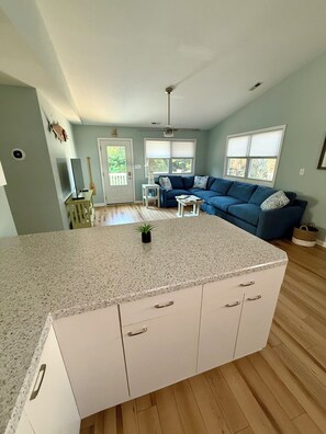 A kitchen with a granite countertop, white cabinets, and a small island. - Middle of the Row Duplex, Quiet, and Cozy, 3 bed/2 bath (Emerald Isle)