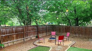 A backyard with a wooden fence, a fire pit, and outdoor seating. - North Austin Hip Duplex (Austin)