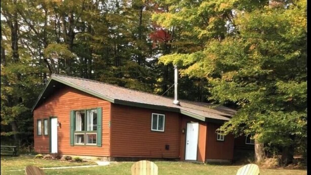 A cabin with a fire pit and Adirondack chairs in the yard. - Killington / Rutland 1 Bdroom Cabin, Cabin #1 (Mendon)