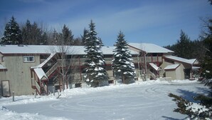 Un edificio con varios balcones y un techo cubierto de nieve.