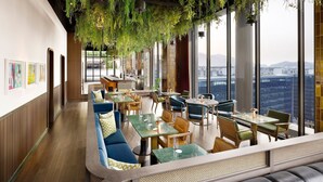 A restaurant with a long counter, seating, and large windows offering a city view. - GRAVITY JOSUN Seoul Pangyo, Autograph Collection (Seongnam)