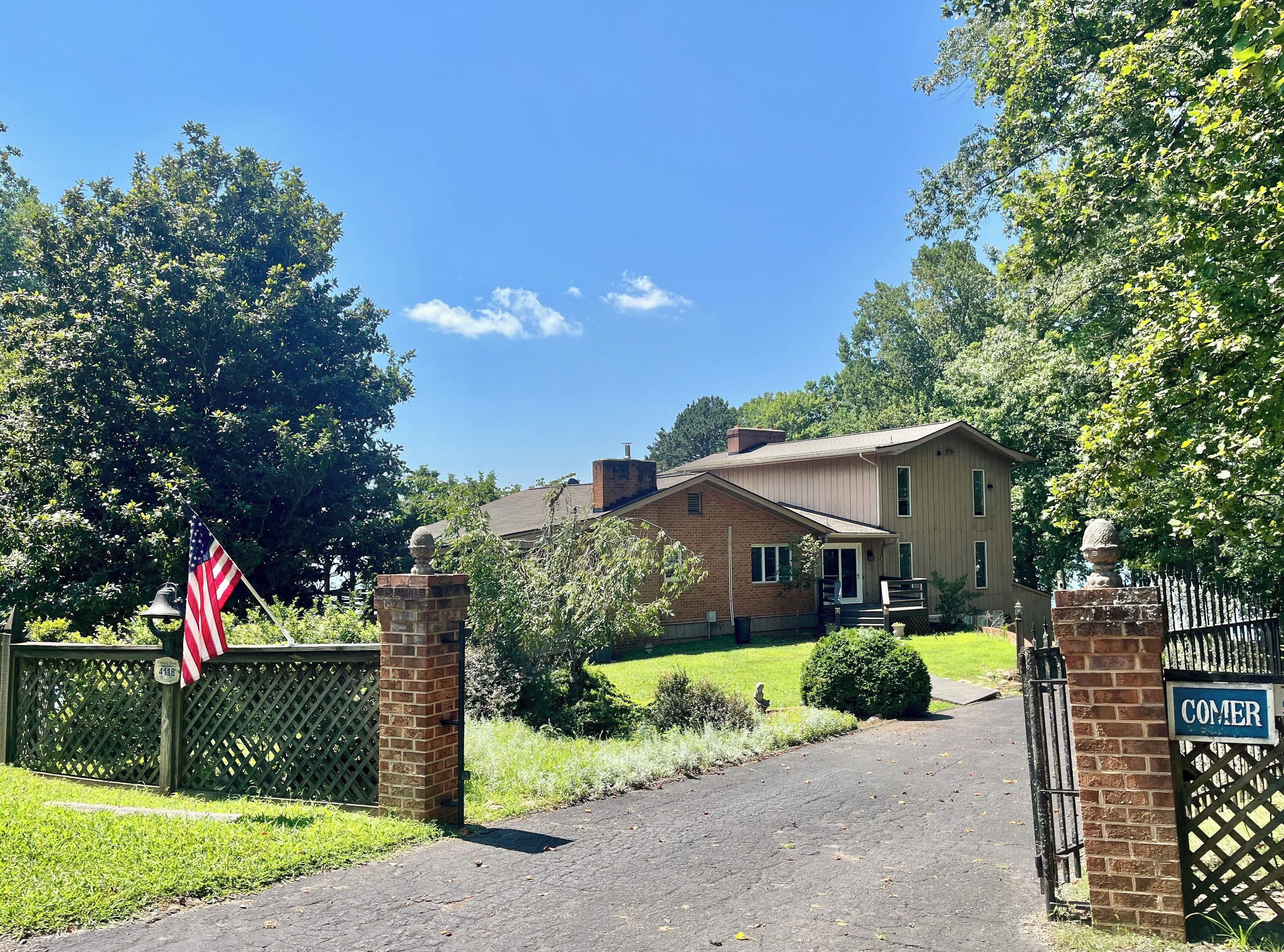 A two-story house with a brick exterior, a front porch, and a mailbox.
