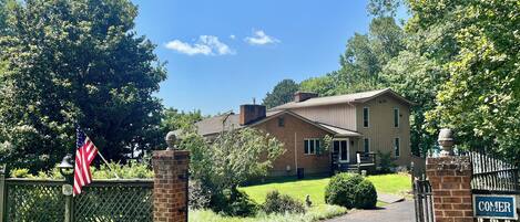 A two-story house with a brick exterior, a front porch, and a mailbox.