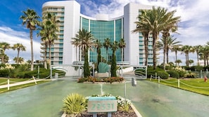 A modern hotel with a curved facade, palm trees, and a sign with the number 29531.