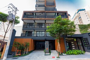 Un bâtiment moderne à la façade noire et blanche, doté de nombreux balcons et d’une enseigne indiquant « Pivô ».