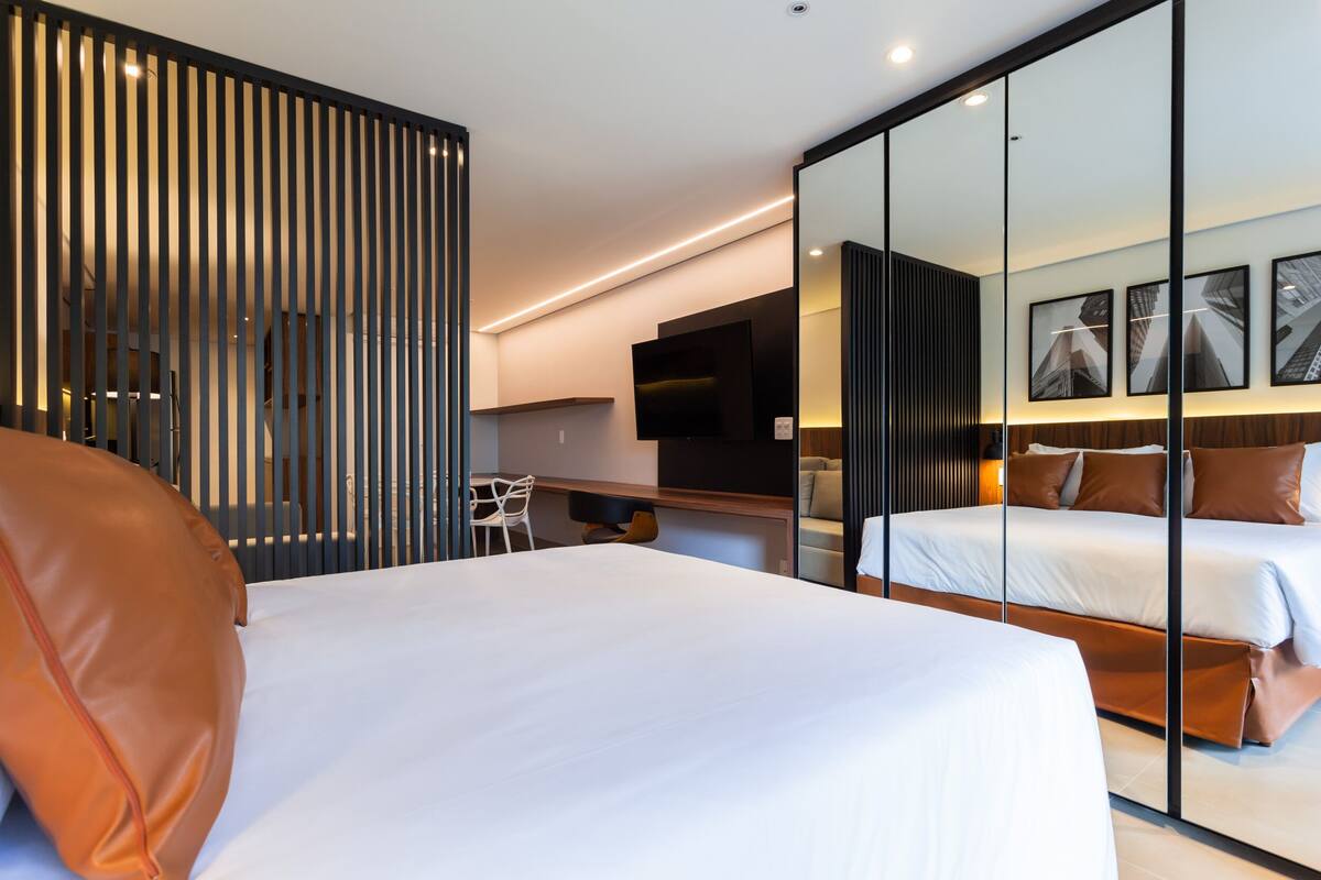Una habitación de hotel moderna con una cama grande, un escritorio y un espacio para sentarse.