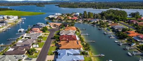 Un quartier résidentiel avec des maisons, une route et un port de plaisance où sont amarrés des bateaux.