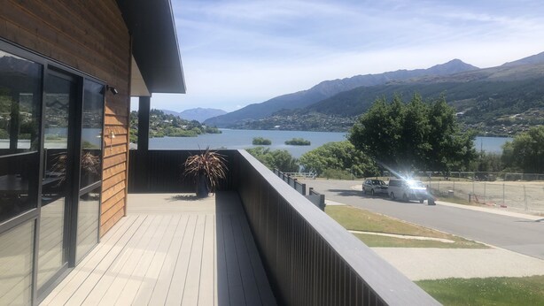Un balcon avec vue sur un lac et des montagnes.