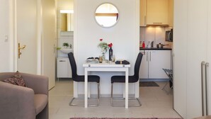 Un espace de vie compact comprenant un coin repas, une kitchenette et un canapé.