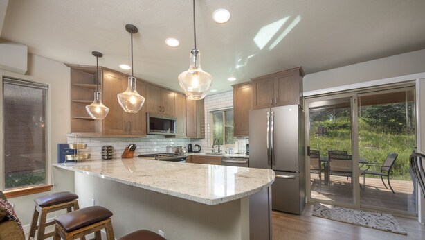 Una cocina moderna con una isla grande, electrodomésticos de acero inoxidable y armarios de madera.