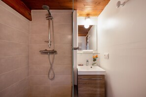 A modern bathroom with a glass-enclosed shower, a white sink with a mirror above it, and a wooden ceiling. - Grand Roc Studio708 280m from Slopes, Parking & WiFi, Argentière (Chamonix), France (Argentière (Chamonix))