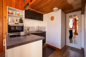 A kitchen with a built-in oven, a coffee maker, and a kettle on the counter. - Grand Roc Studio708 280m from Slopes, Parking & WiFi, Argentière (Chamonix), France (Argentière (Chamonix))