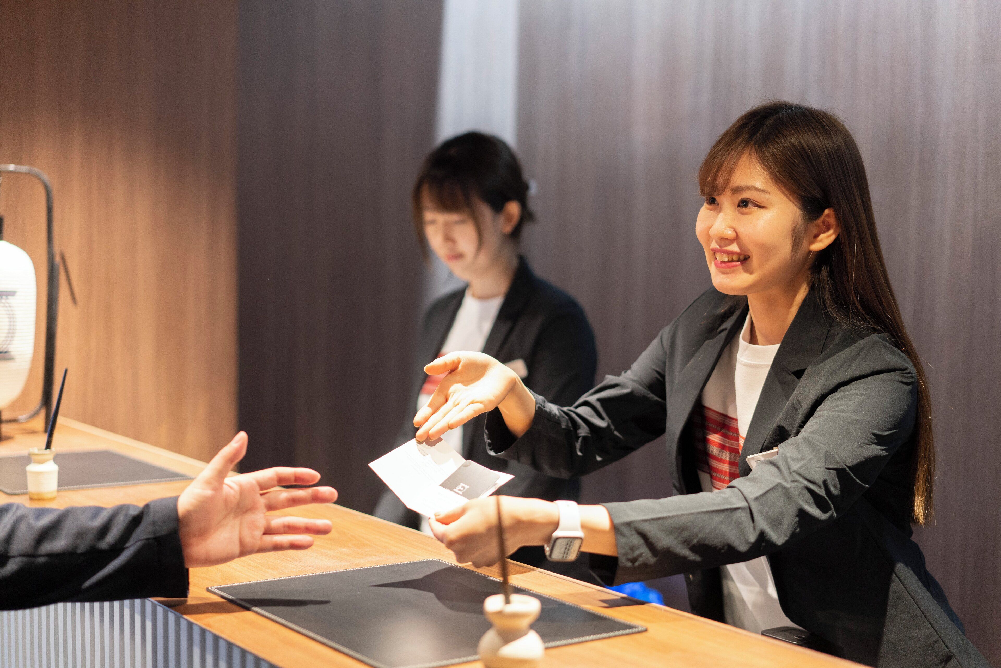 A business meeting with a wooden table, a laptop, and a smartphone on it.