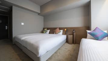 A hotel room with a large bed, a smaller bed, a nightstand, and a bedside table.