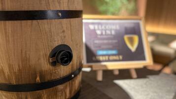Un barril de madera con una correa negra y una etiqueta que dice "WELCOME WINE".