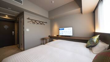 Ein Hotelzimmer mit einem großen Bett, einem Nachttisch, einem Fernseher und einem Fenster mit Vorhängen.