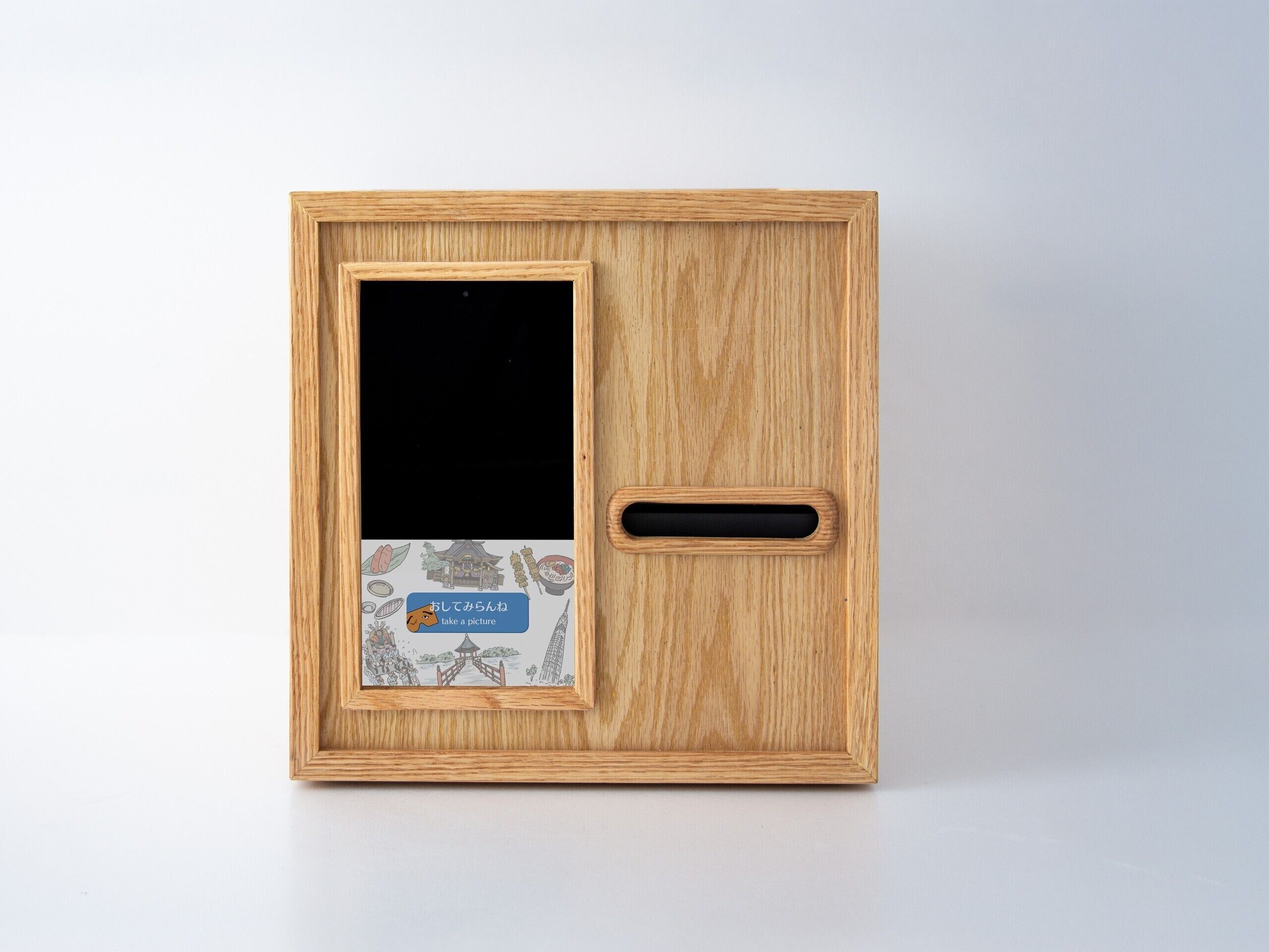 A wooden photo frame with a black screen and a label with Japanese text.
