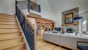 A modern kitchen with wooden cabinets, a stone accent wall, and a fireplace.