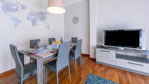 A modern dining area with a world map, a clock, and a flat-screen TV. - Appartamento Il Golfo: Lake View in Laveno-mombello (Laveno Mombello)